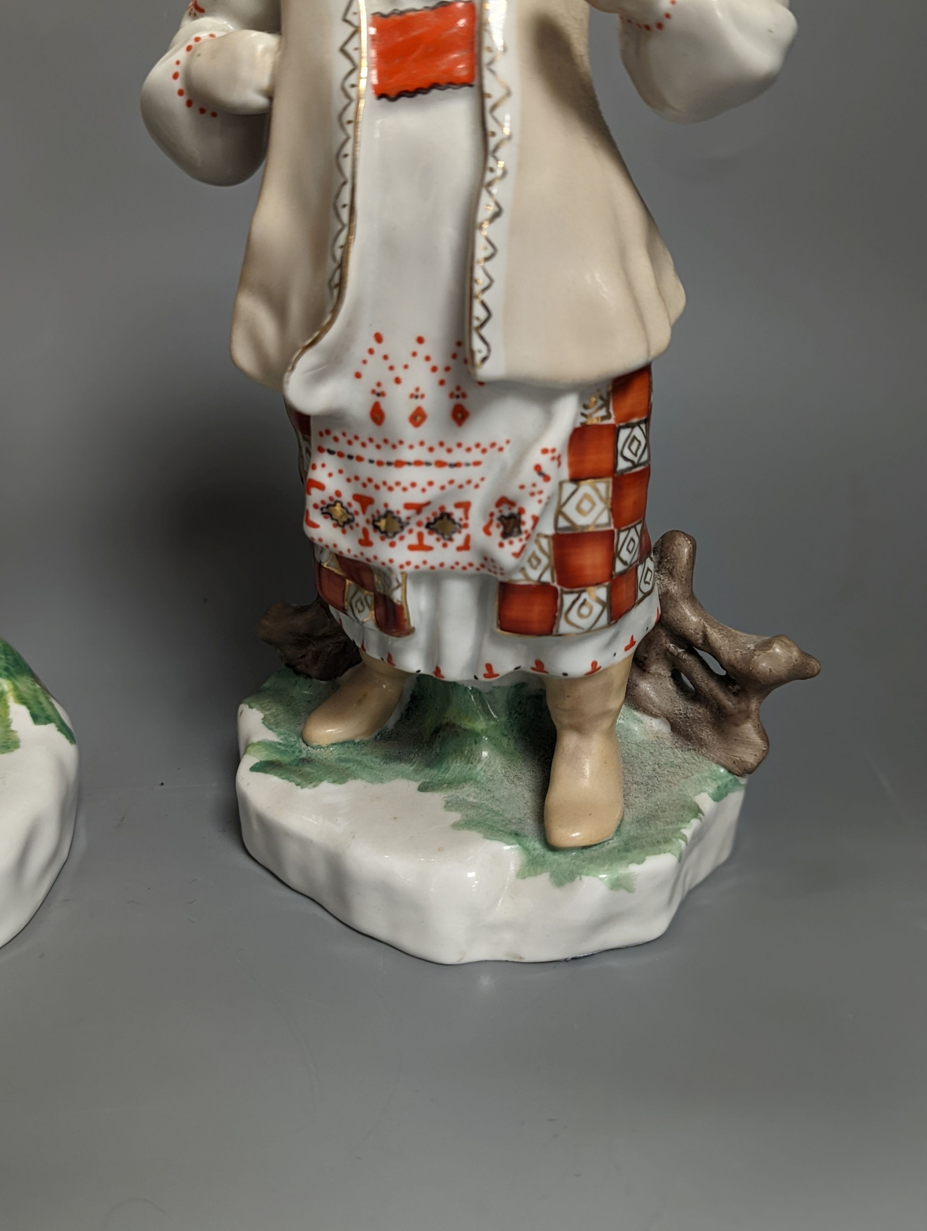 A pair of Russian porcelain figures of a Cossack and his wife 25cm